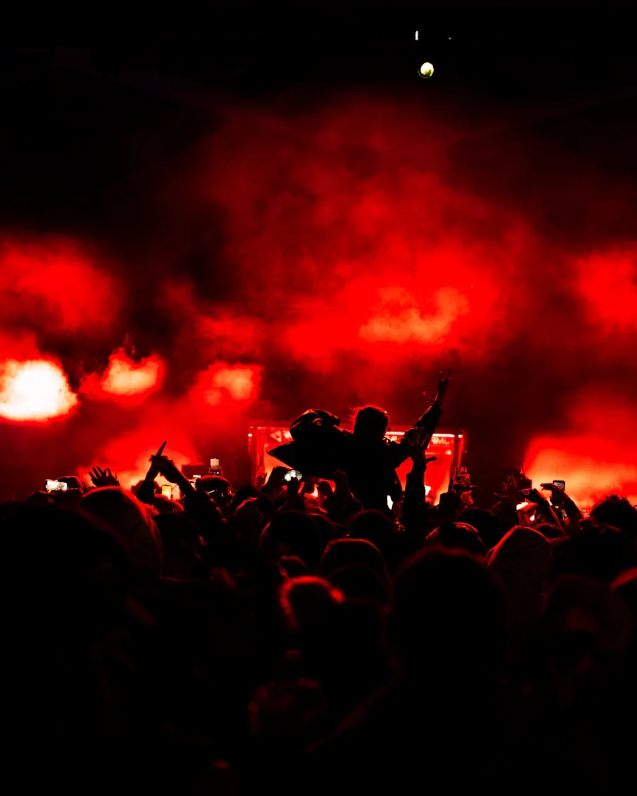 Público de un concierto bajo luces rojas